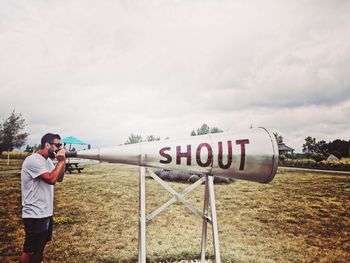 Man shouting on megaphone while standing on land