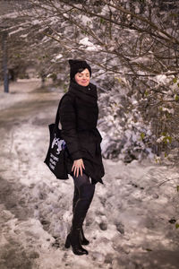 Full length of woman standing on snowcovered land