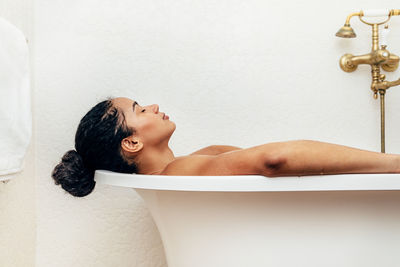 Woman relaxing in bathtub at bathroom