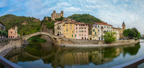 Buildings by lake against sky