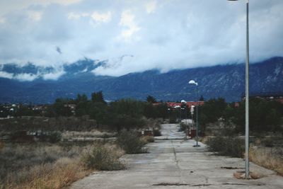 Scenic view of buildings by mountains against sky