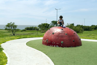 Photo of child on top of children's climbing semi-sphere