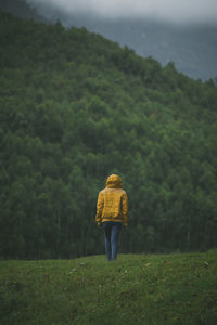 Rear view of woman standing on field