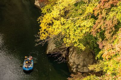 High angle view of people sailing in boat by rock formation in river