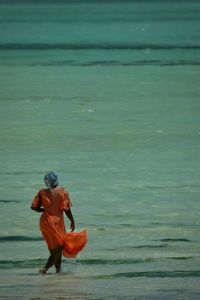 Rear view of man walking at beach