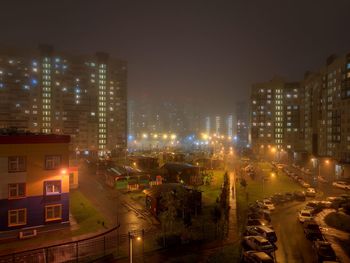 High angle view of illuminated cityscape against sky at night