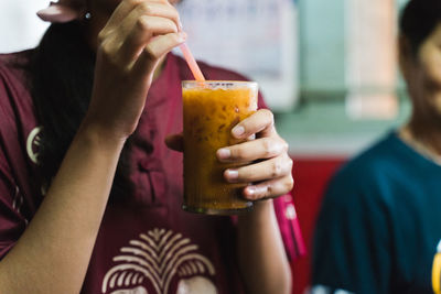 Midsection of woman drinking glass