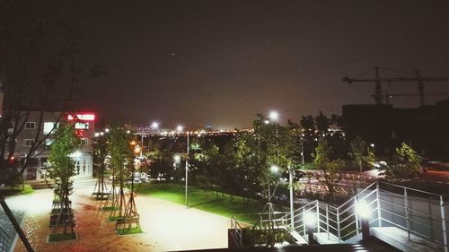 Illuminated cityscape against sky at night