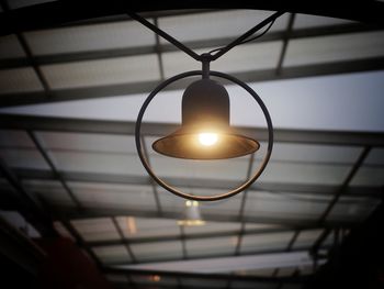 Low angle view of illuminated lighting equipment hanging from ceiling