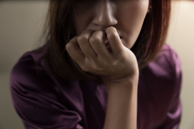 Midsection of woman with hand on chin