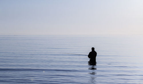 Silhouette duck swimming in sea