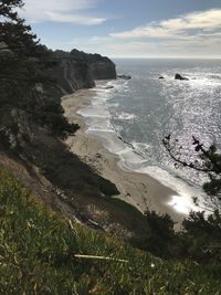 Scenic cliff view of ocean against sky. 