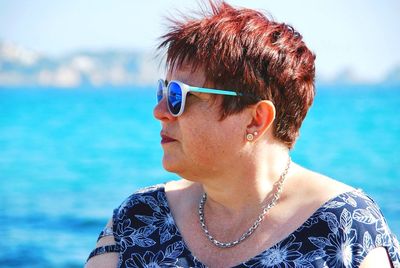 Portrait of mid adult man looking away against sea
