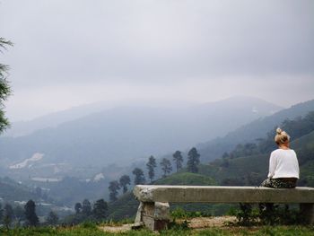 Rear view of woman standing on mountain landscape