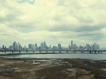 View of cityscape against cloudy sky