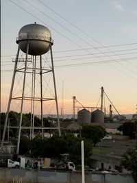 Low angle view of water tower against sky at sunset