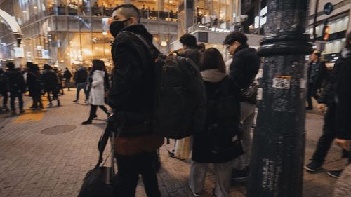 Group of people walking on city street at night