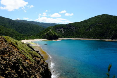 Scenic view of sea and mountains against sky