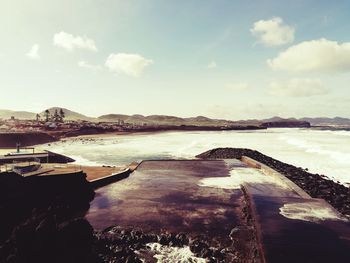 Scenic view of lake against cloudy sky