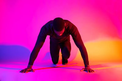 Full length of woman standing against pink background