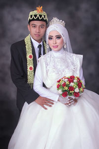 Midsection of couple holding bouquet