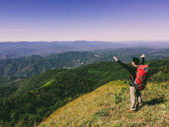 Rear view of man standing on landscape against sky