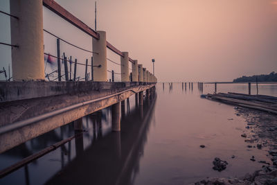 Reflection of built structure in water at sunset