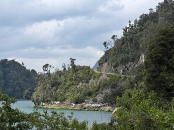 Scenic view of river and mountains against sky