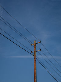 Low angle view of electricity pylon against sky