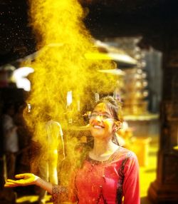 Smiling woman throwing turmeric 