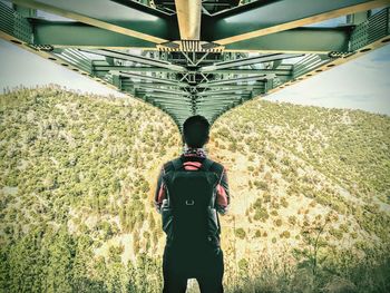 Rear view of man standing on road against sky