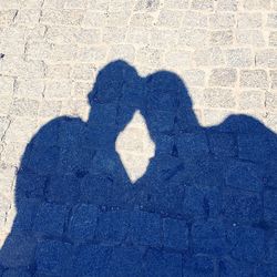 Shadow of man holding heart shape on street