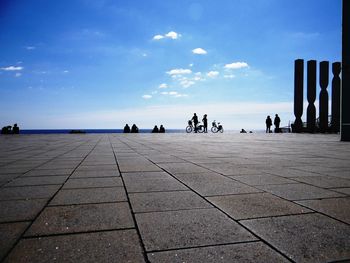 People by sea against sky