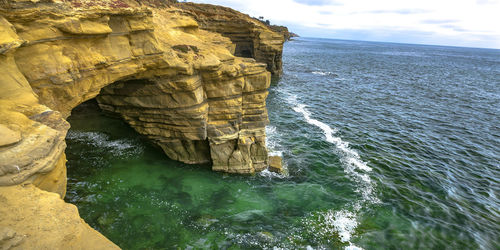 Rock formation in sea against sky