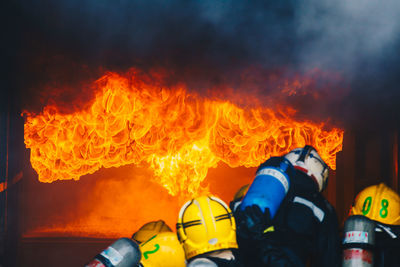 Rear view of firefighters extinguishing fire