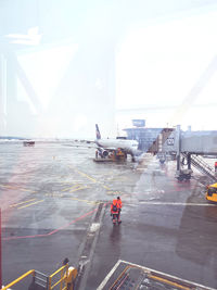 Airplane on airport runway against sky