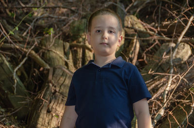 Portrait of boy standing against plants