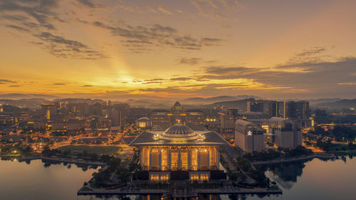 Aerial view of buildings against cloudy sky during sunset