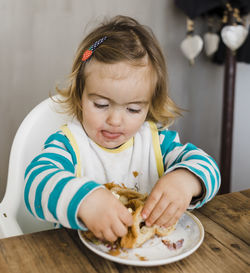 Cute girl eating at table