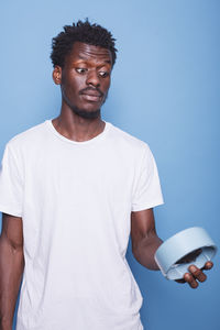 Portrait of man standing against blue background