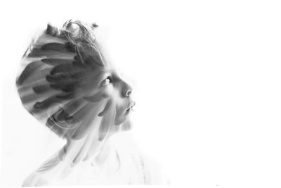Double exposure of boy with flowers against white background