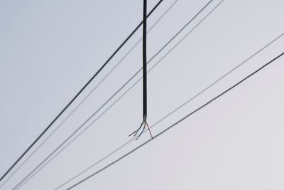 Low angle view of power lines against clear sky