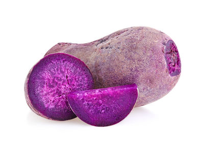 Close-up of purple fruit against white background