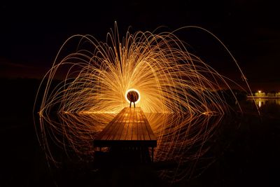 Person spinning wire wool on pier