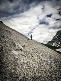 Low angle view of woman walking on mountain against sky