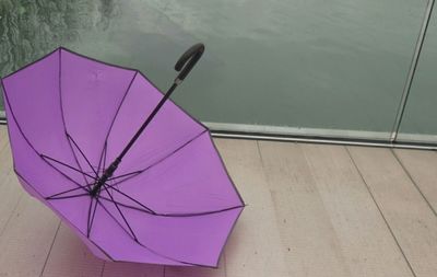 High angle view of purple umbrella on boardwalk over lake