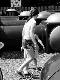 Rear view of women standing on car in city