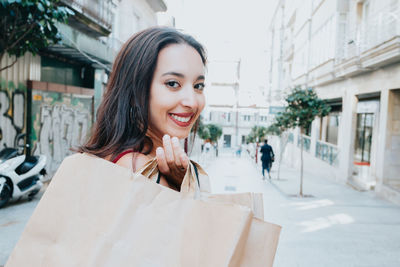 Portrait of young woman holding shopping bags