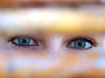 Close-up portrait of woman seen through blinds