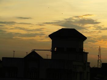 Silhouette house against sky during sunset